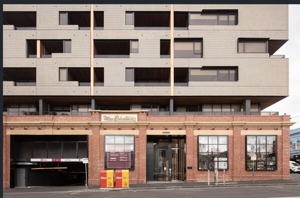 A multi-story building with a flat facade, large windows, and a ground-level garage. - Bright 2-bed Apartment in Fitzroy's Heart (Melbourne)