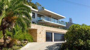 A modern two-story house with a stone facade, large windows, and a balcony. - Ocean Views, Deck and Parking at Beach Apartment (Sydney)