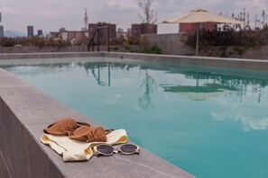 Una piscina con una toalla y unas gafas de sol en el borde.