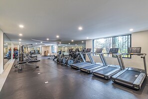 A gym with multiple treadmills, exercise bikes, and weight machines.