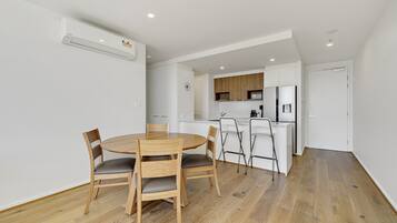 A modern kitchen with white cabinets, a built-in microwave, and a stainless steel refrigerator.