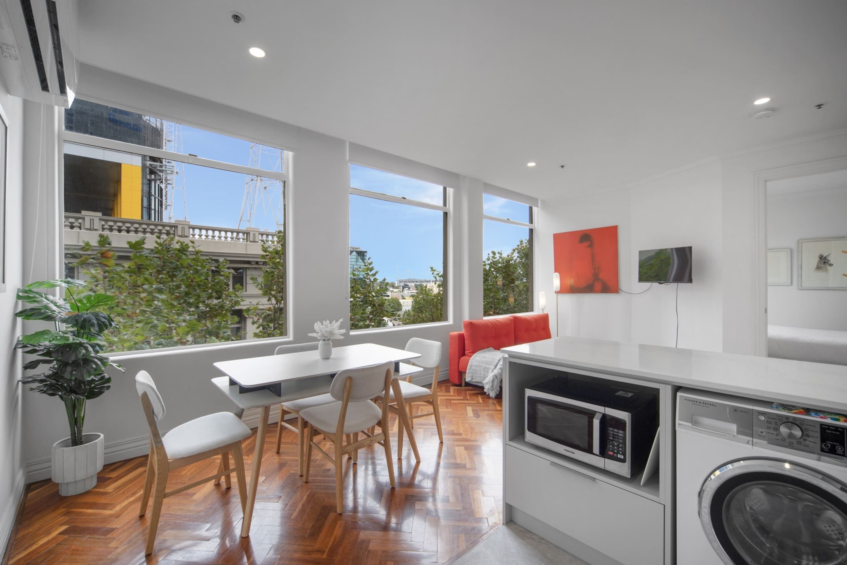 Una cocina moderna con comedor, ventanas amplias y vistas a la ciudad.