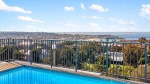 Ein Pool mit Blick auf eine Küstenstadtlandschaft, einschließlich eines Hafens und Wohngebäuden.