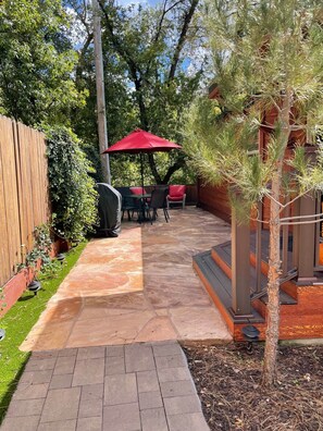 A patio with stone flooring, a wooden fence, and a red umbrella. - Christopher Creek Cabins - Cabin 2 (Christopher Creek)