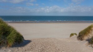 Une plage avec un ciel dégagé et une mer calme.