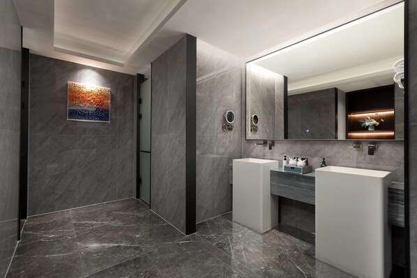 A modern bathroom with two sinks, a large mirror, and a decorative wall piece.