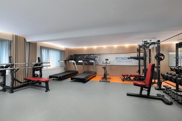 A modern gym with treadmills, a stationary bike, and weightlifting equipment. - Microtel By Wyndham Enshi Jianshi (Enshi)