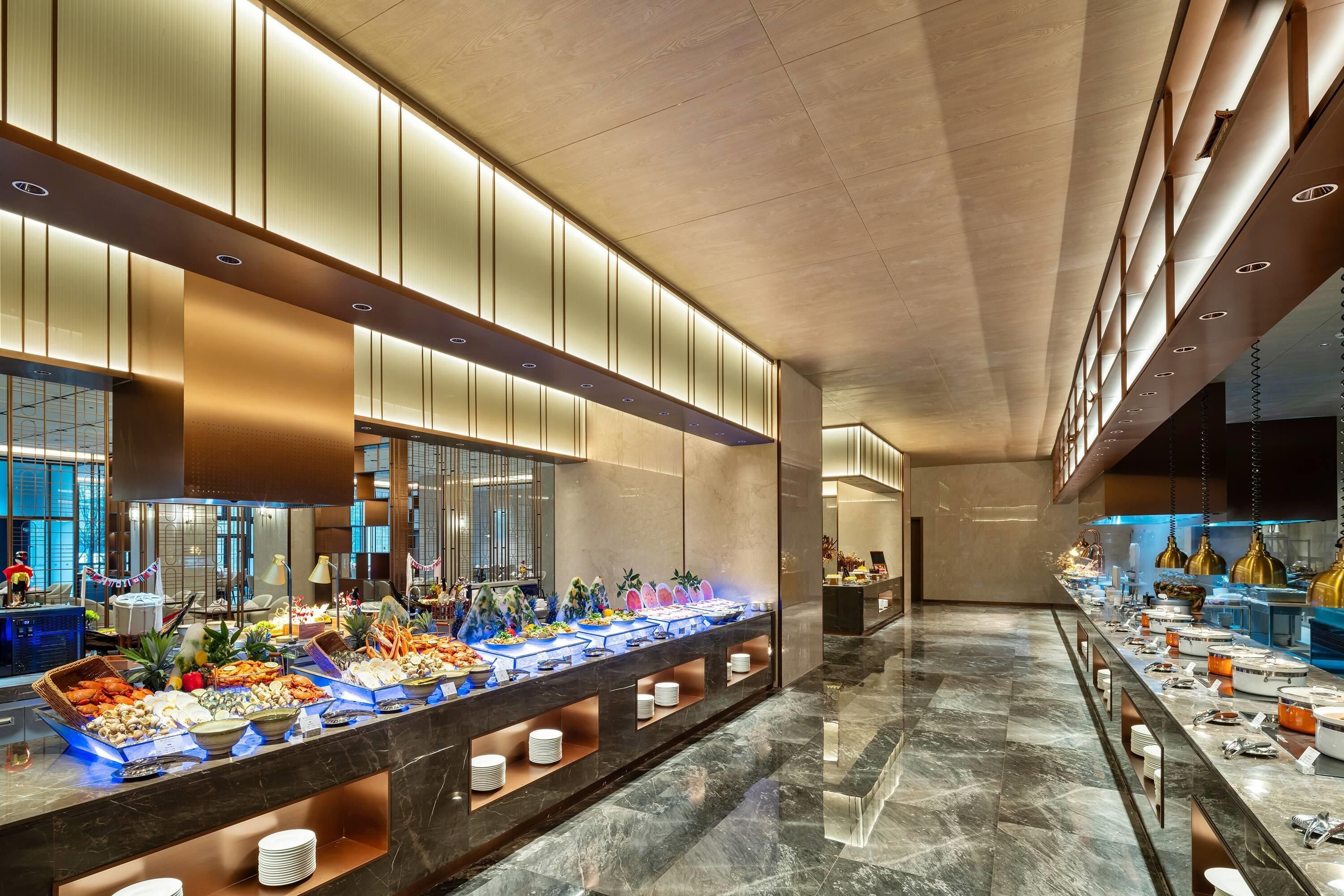 A buffet setup with various food items and a modern interior design.