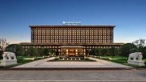 Un gran edificio de hotel con un letrero llamativo que dice 'WYNDHAM GRAND Plaza Royale Longchang'.