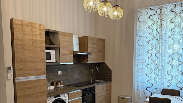 Ett modernt kök med träinredning, en inbyggd tvättmaskin och en matplats med bord och stolar.