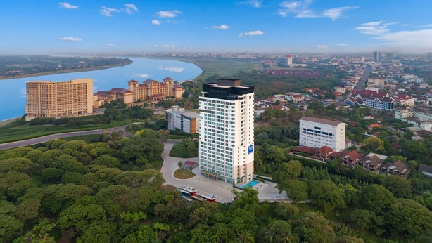 Un hôtel de grande hauteur offrant une vue sur une rivière et la végétation environnante.