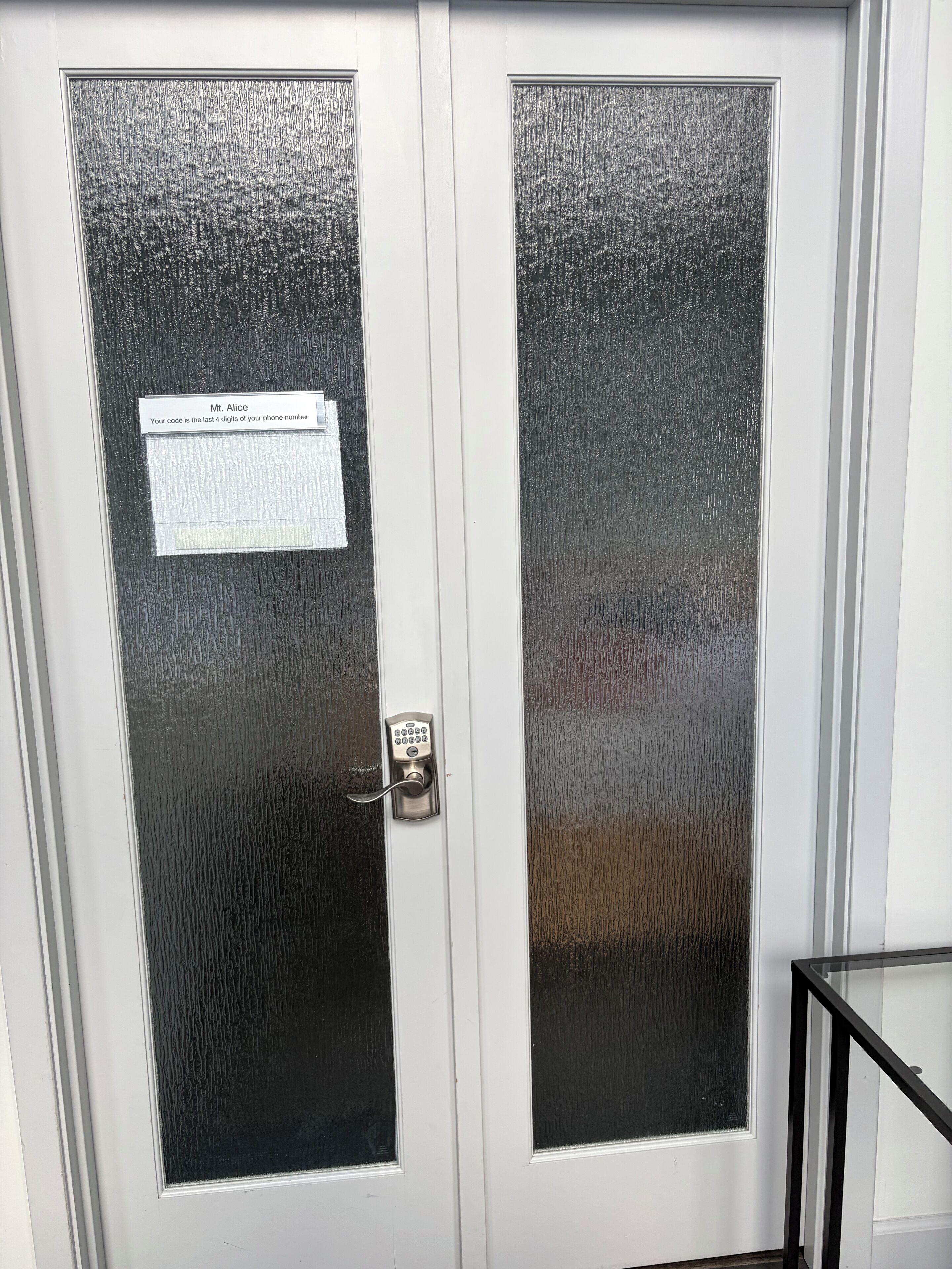 A door with a frosted glass panel and a keypad lock.