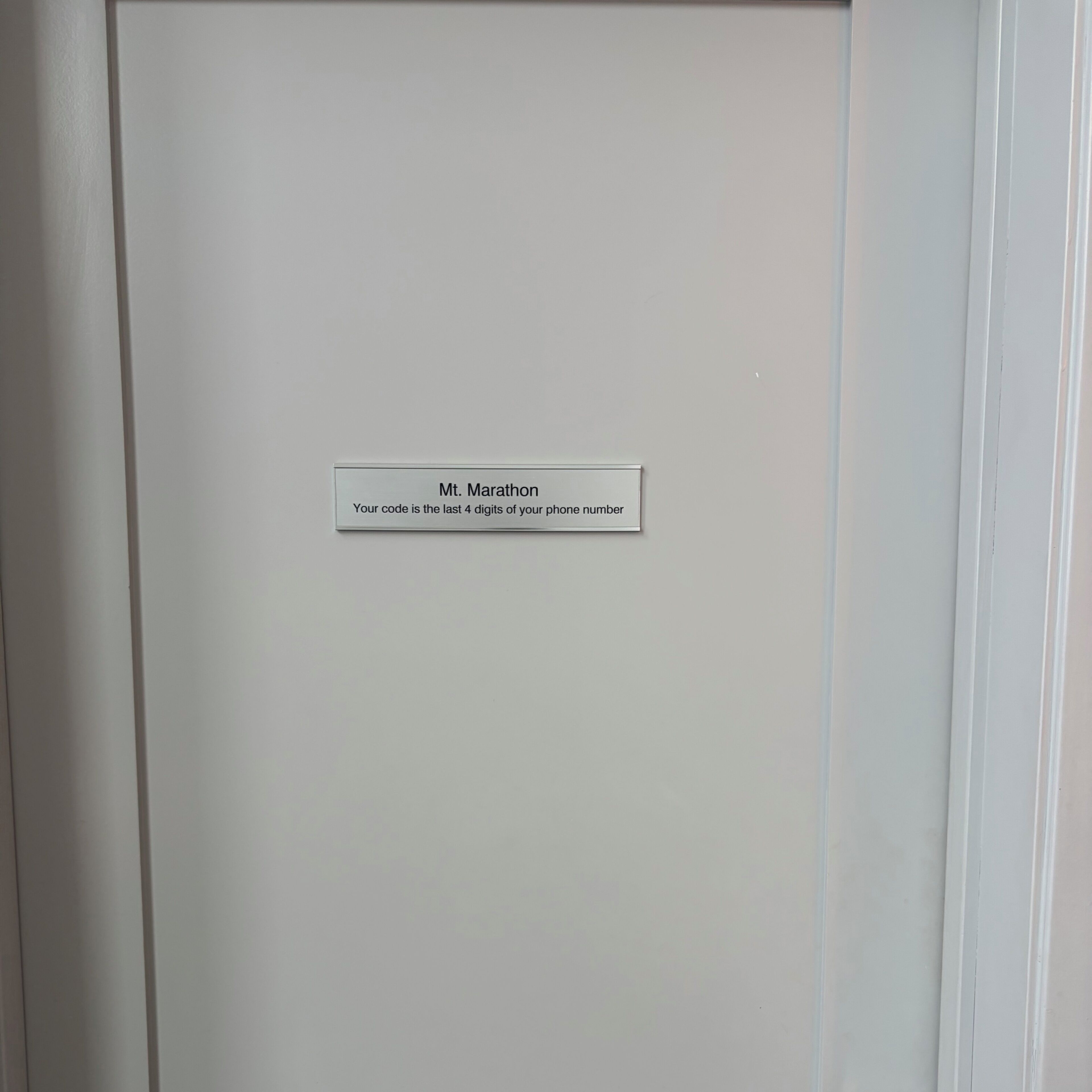 A white door with a label that reads "Mt. Marathon Your code is the last 4 digits of your phone number."