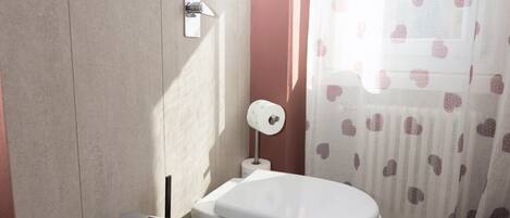 A bathroom with a bidet, toilet, and sink.