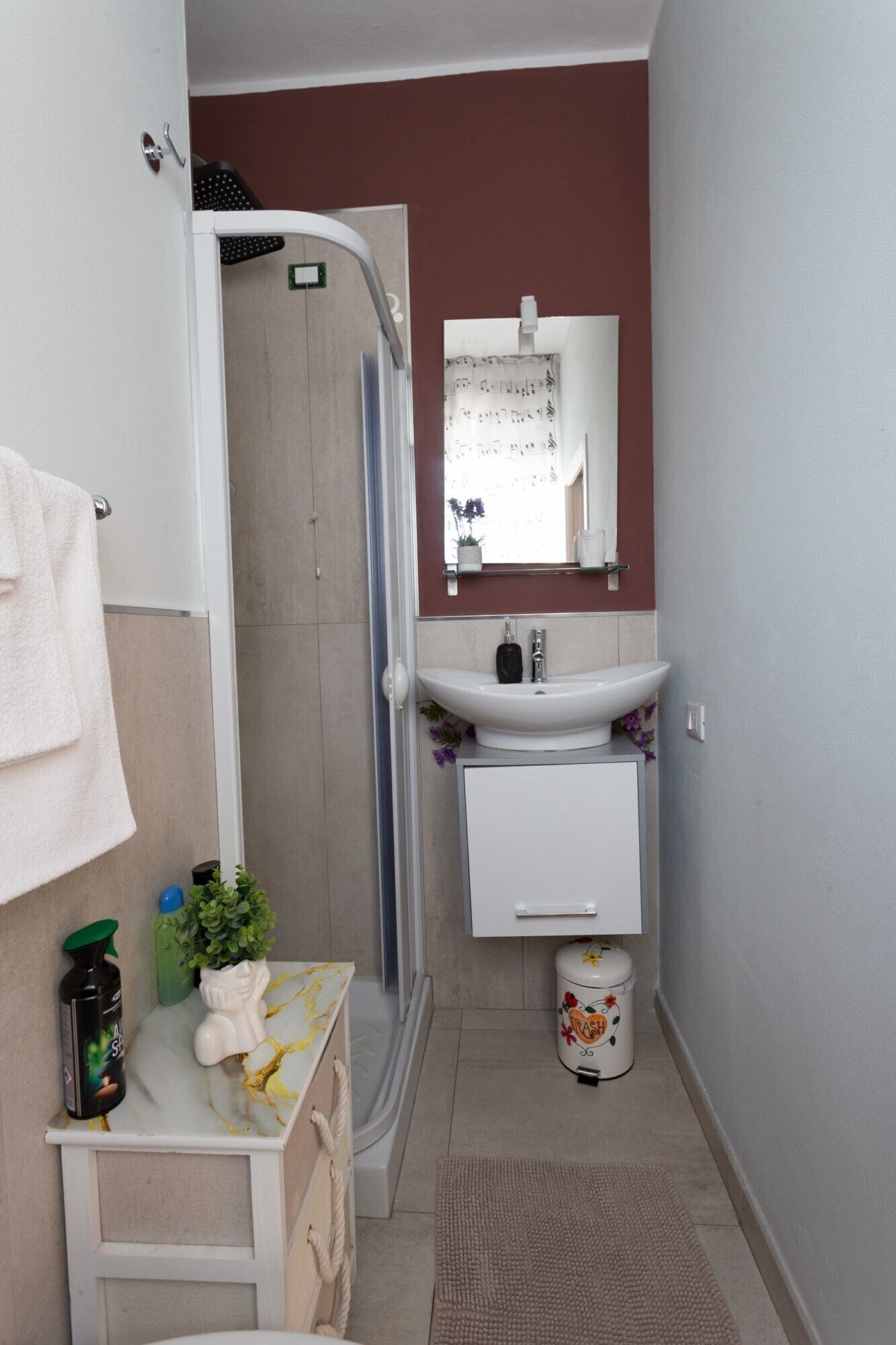 Un baño con ducha, lavabo, espejo e inodoro.