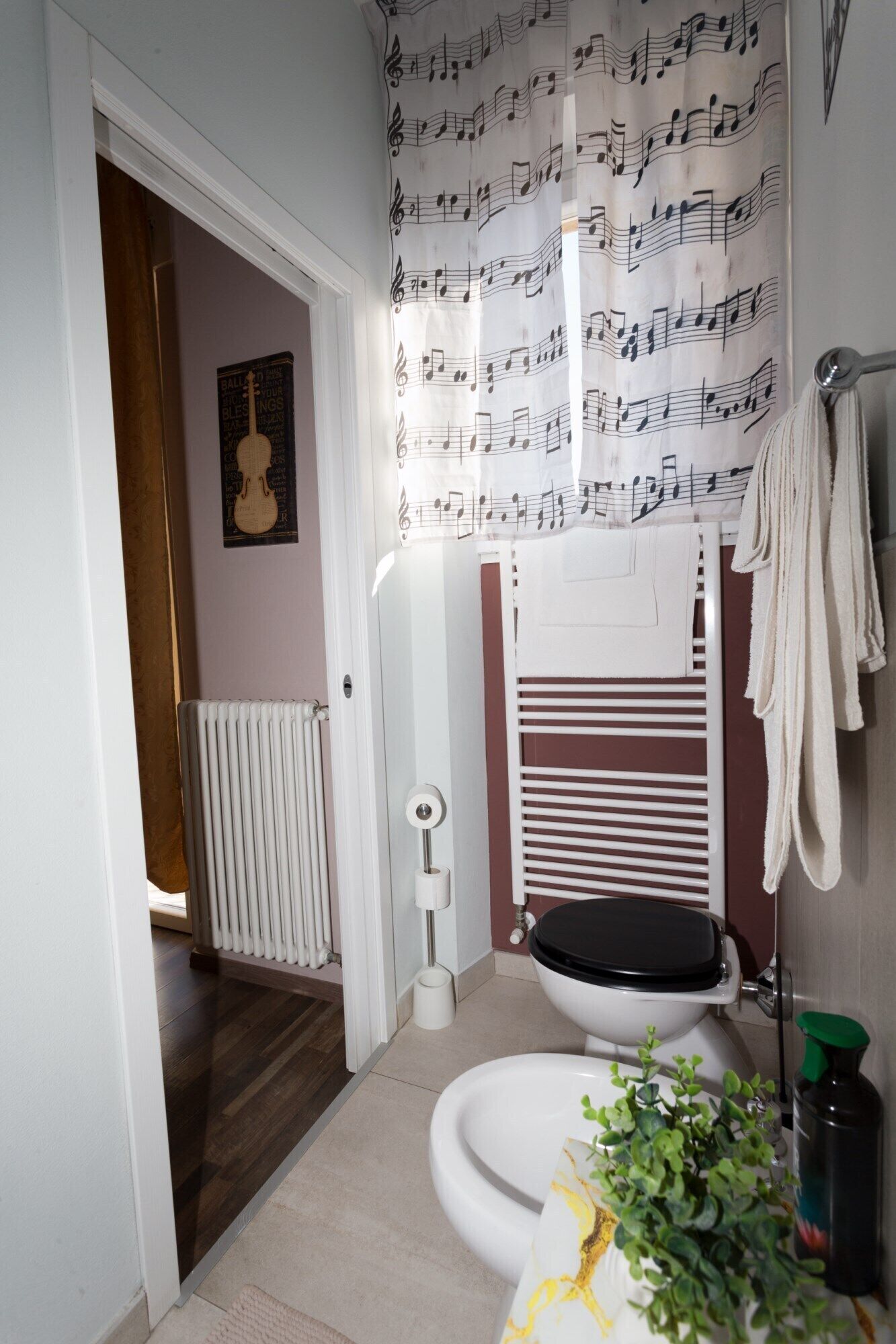 A bathroom with a toilet, bidet, and towel rack.