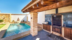 An outdoor pool area with a stone wall, a statue, and a barbecue grill. - El Nacimiento Santa Elena by Ruralidays (Jaén)