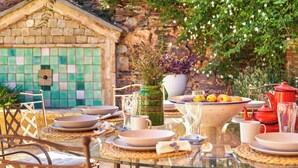 A table set for a meal with plates, bowls, and a vase of flowers. - El Nacimiento Santa Elena by Ruralidays (Jaén)