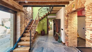 A staircase with wooden steps and metal railings, leading to a room with a green wall and a potted plant. - El Nacimiento Santa Elena by Ruralidays (Jaén)
