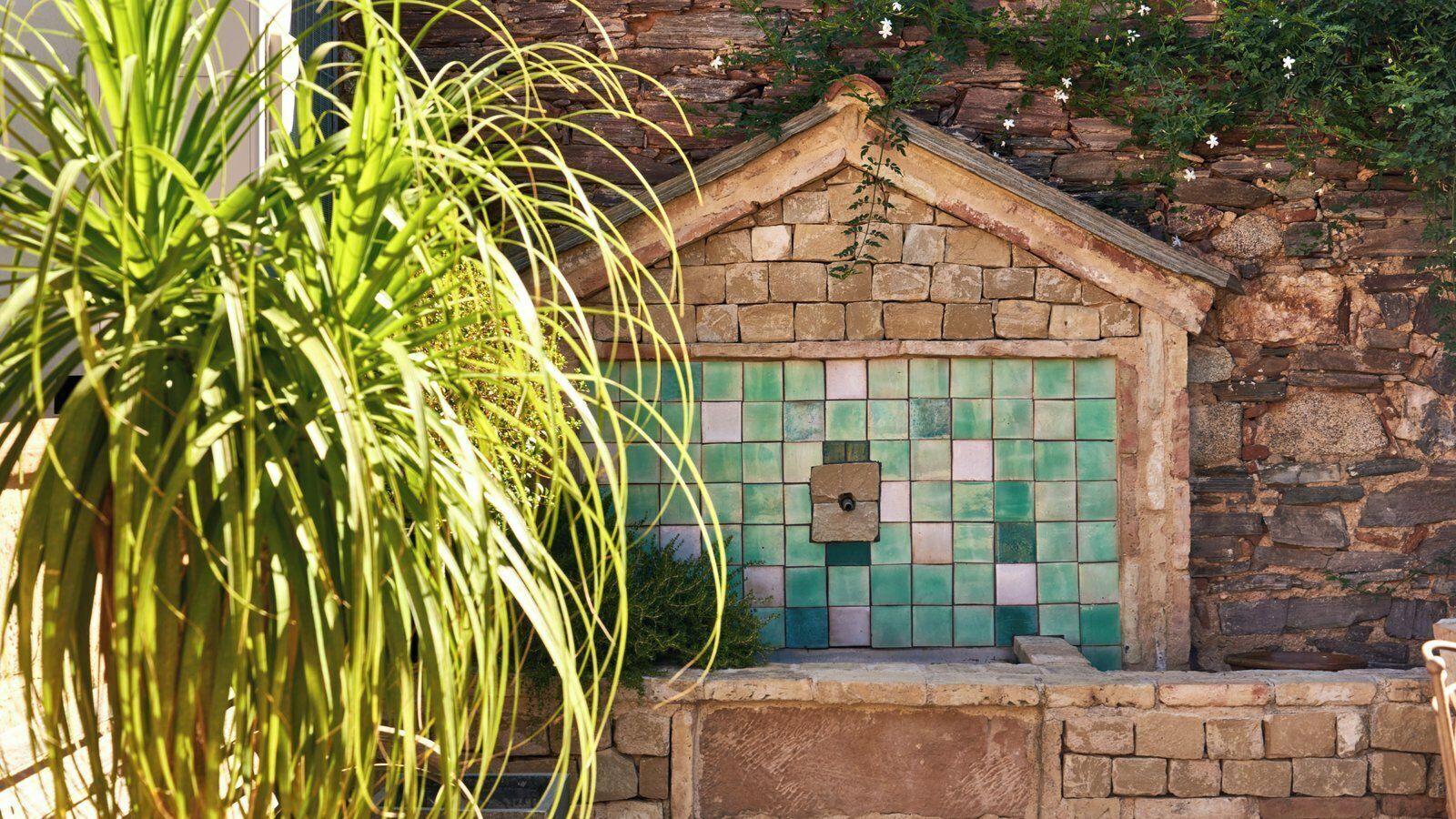 A stone building with a tiled door and a small window.