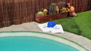 Un espace piscine agrémenté d’une clôture en bois, d’un pot de cactus et d’une serviette ornée du logo « ruraldays ».