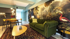 Een moderne woonkamer met een groene bank, een houten salontafel en een kamerbreed tapijt met een patroon.
