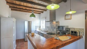 A kitchen with a wooden countertop, stainless steel appliances, and a tiled backsplash. - La Era del Bonete Constantina by Ruralidays (Sevilla)