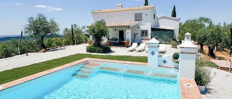 A swimming pool with a white house in the background.