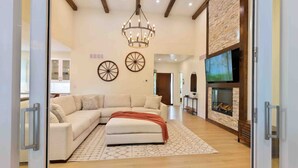 A spacious living room with a sectional sofa, a fireplace, and a large TV.