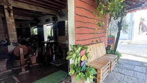 A rustic outdoor seating area with wooden benches and potted plants. - Pousada Berro do Bode (Cabaceiras)