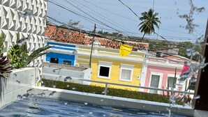 A swimming pool with clear water, surrounded by buildings with colorful facades. - Pousada Berro do Bode (Cabaceiras)
