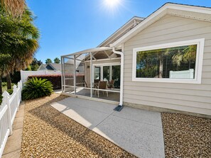 A house with a covered patio, a fenced yard, and a large window. - Sunshine Stay a Creekside Villa at Lake Sumter Landing with Nature & Water Views (The Villages)
