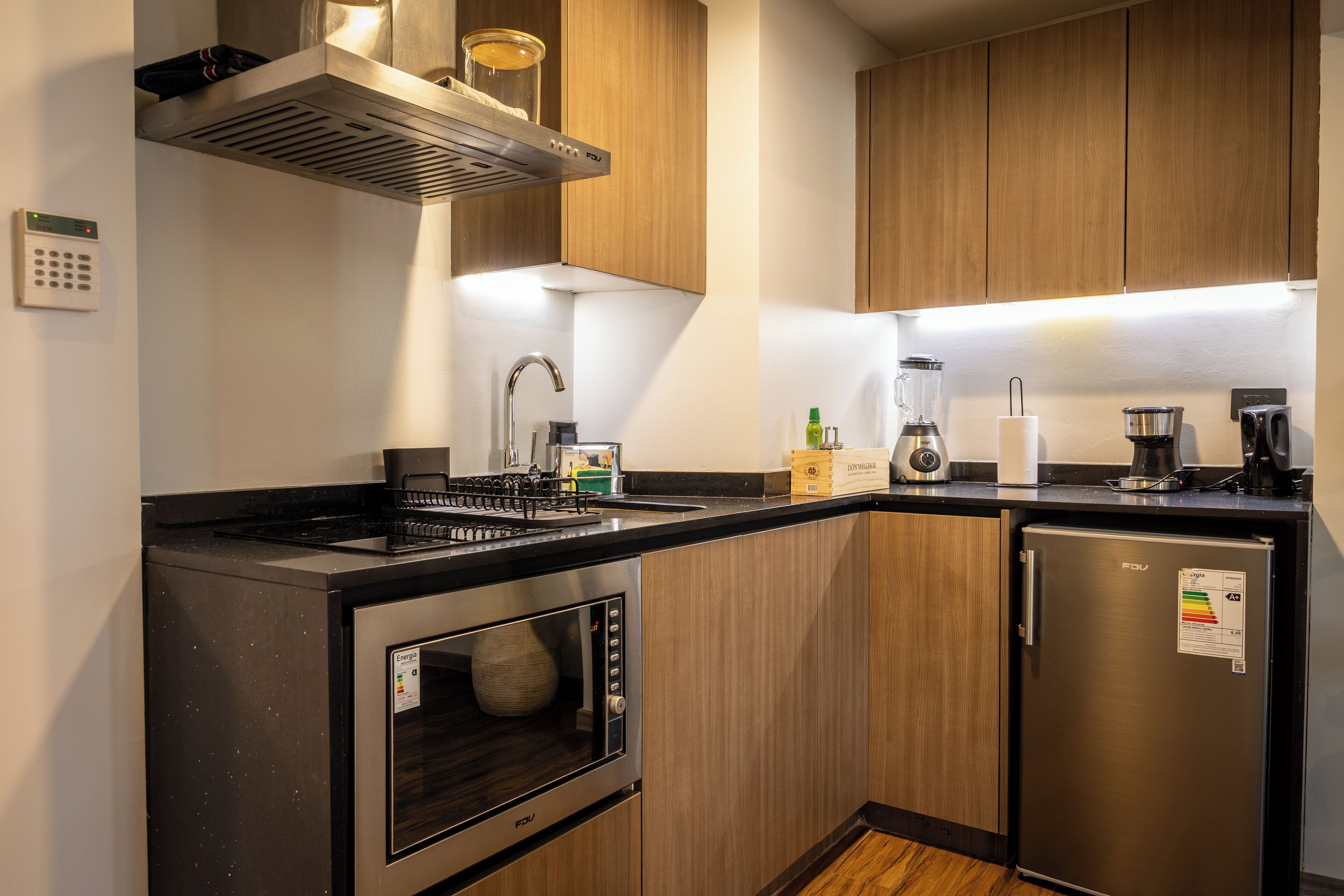 A modern kitchen with stainless steel appliances, wooden cabinets, and a built-in oven.