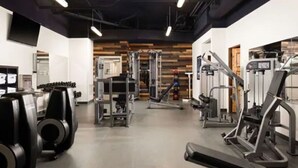A gym with various exercise equipment, including weight machines and a treadmill.