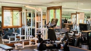 A gym with various exercise equipment, including treadmills, weight machines, and free weights.