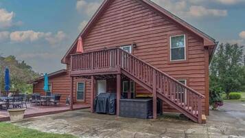 A two-story wooden building with a balcony and outdoor seating area.