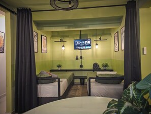 A room with two beds, a TV mounted on the wall, and a small table with a plant. - Casa Árbol accessible, spacious, and cozy home just minutes from downtown La Paz (La Paz)