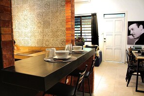 Una cocina con una encimera de madera larga, un salpicadero con diseño y una puerta con un cartel.