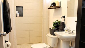 Een badkamer met toilet, wastafel en douche.