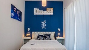 Une chambre à coucher comprenant un lit, des tables de chevet, une horloge murale, un globe terrestre et une citation inspirante.