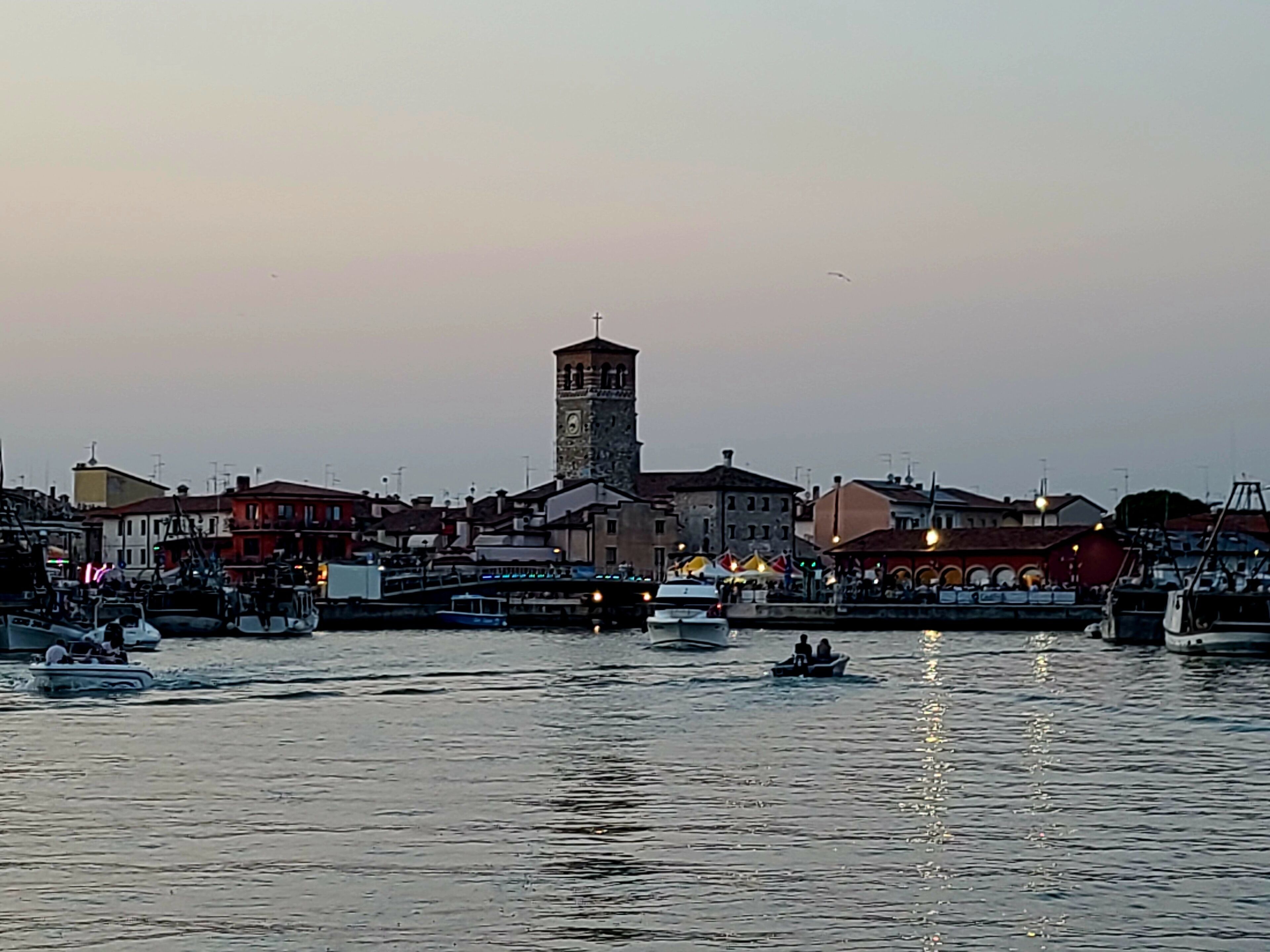 A waterfront area with boats, a tower, and buildings along the shore.