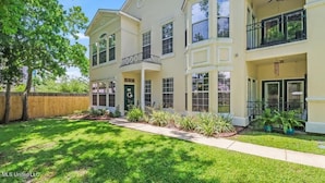 A two-story residential building with a front porch, a covered entryway, and a small balcony. - Legacy Villa 2602 - 3 Bedroom 2 Bath With Garage in Beachside Neighborhood (Gulfport)