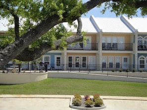 A building with a white roof, multiple windows, and a black fence.