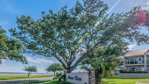 Une enseigne indiquant « Belle Claw », avec un grand arbre devant, une pelouse bien entretenue et un bâtiment doté d’un balcon.
