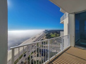 Un balcon avec vue sur une plage et sur le paysage urbain.
