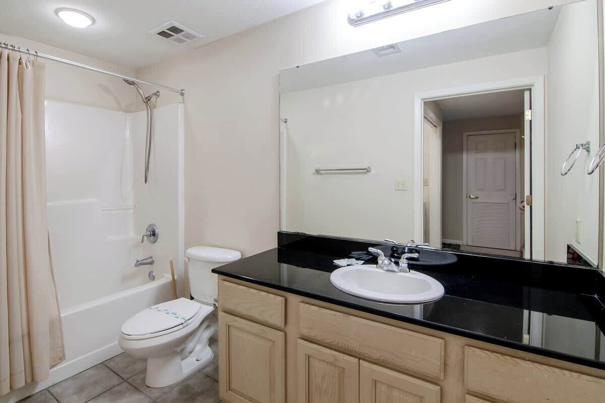A bathroom with a bathtub, toilet, and sink.