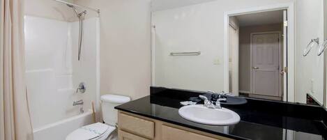 A bathroom with a bathtub, toilet, and sink.