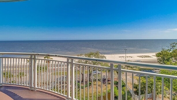 A balcony with a view of the sea and beach.