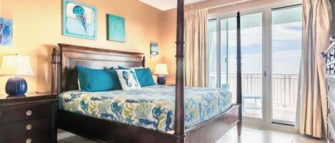 Un dormitorio con cama con dosel, ventilador de techo y balcón con cortinas.