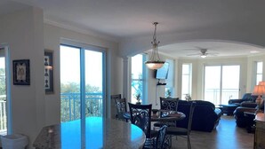 Un vaste espace de vie comprenant une grande fenêtre, une table à manger et un îlot de cuisine.